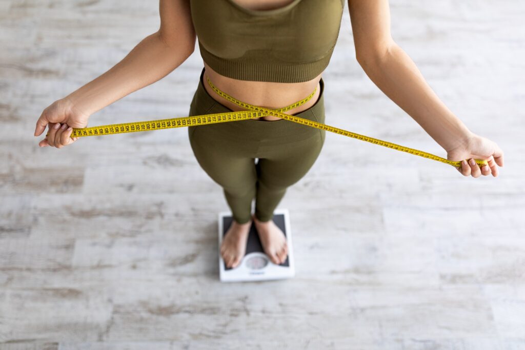 closeup of indian female measuring waist standing 2023 11 27 04 55 57 utc